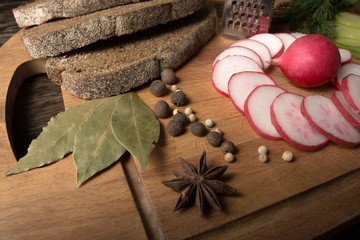 Green radish, red garden radish and pieces of rye bread