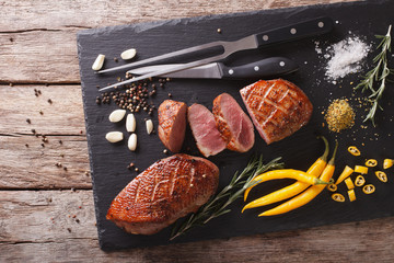 Wall Mural - Delicious sliced roast duck breast closeup on a slate board. horizontal top view