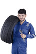 © Creativa Images - Arabian mechanic holds tyre and wrench