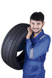 © Creativa Images - Arabian mechanic lifting car tyre
