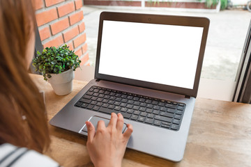 Woman using laptop with blank screen on table at coffee shop