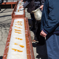 Wall Mural - Man pouring hot maple syrup on snow