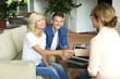 © sepy - Handshake. Shot of an investment advisor businesswoman consulting with her clients. Middle aged woman and professional agent shaking hands after making deal.
