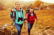 © baranq - Couple hiking during autumn vacation with sticks and backpacks