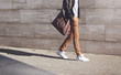 © guas - Street fashion, african man in black rock leather jacket with bag walking in evening city