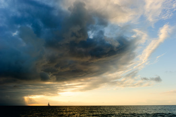 Wall Mural -  Ocean Storm Sailboat Sunset Approaching Looming Dramatic Hope Faith Sky