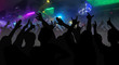 © andriano_cz - Silhouettes of concert crowd with hands raised at a music disco
