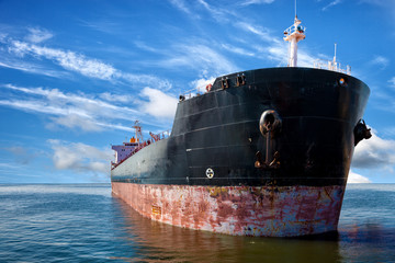 Oil tanker ship at sea on a background of blue sky.