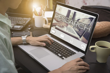 Wall Mural - business hand typing on a laptop keyboard with research homepage on the computer screen information 