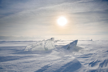 boundless icy landscape during a snowstorm at sunset in winter.