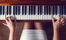 Top View Of Young Woman Playing The Piano