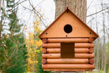 Fototapeta Krajobraz - Wooden birdhouse in a beautiful autumn Park