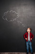 © Drobot Dean - Kid thinking with thought bubble at chalkboard, looking on painting