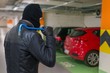 © vchalup - Thief in balaclava holds crowbar in hand and is going to steal a car from parking lot.