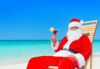 Canvas Print - Christmas Santa Claus with cocktail on sunlounger at tropical beach