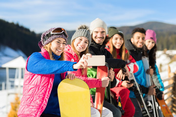 Wall Mural - People Group With Snowboard And Ski Resort Snow Winter Mountain Cheerful Taking Selfie Photo Friends Hands Having Fun