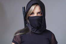 Samurai Woman Dressed In Black With Matching Veil Covering Face, Sword Hidden Behind Back, Facing Camera, Ninja Concept