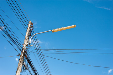 Power lines and lamp with blue sky.