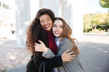 Poster - Happy meeting of two friends hugging in the street