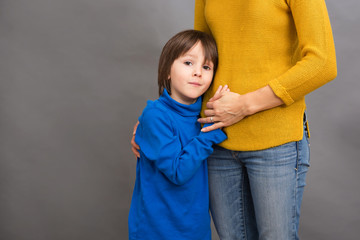 Wall Mural - Sad little child, boy, hugging his mother at home, isolated imag