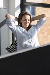 Business woman leaning back in her chair relaxing at her office desk