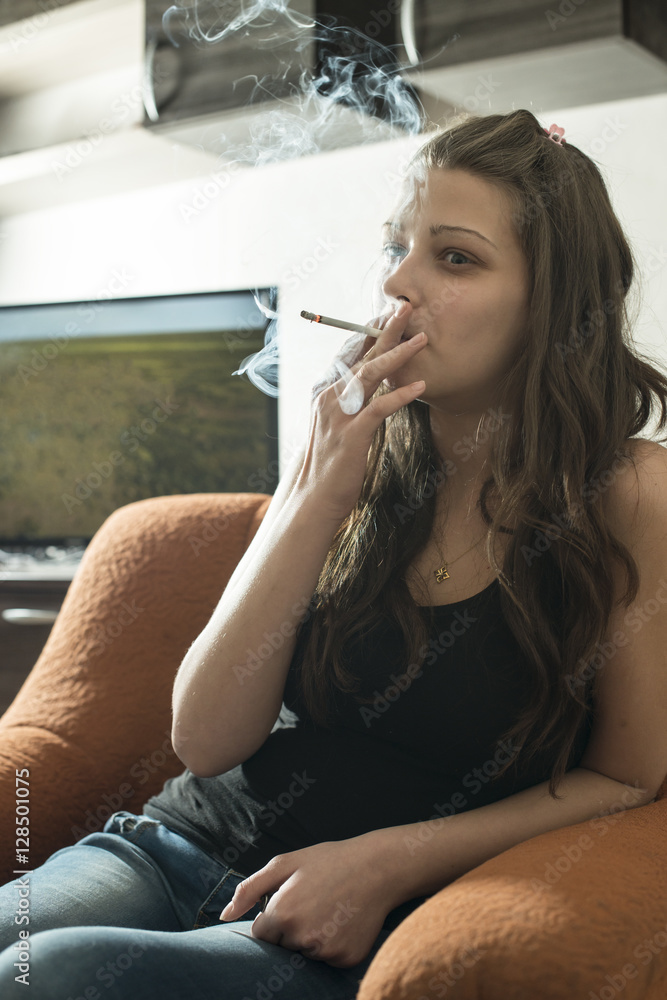 Girl smoke cigarette in the room. Close up smoker. Stock Photo
