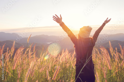 Fotografía Carefree Happy Woman Enjoying Nature on grass meadow on top of mountain cliff with sunrise