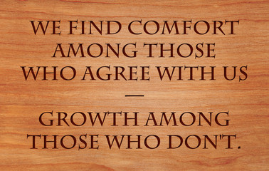 We find comfort among those who agree with us — growth among those who don't - quote on wooden red .oak background