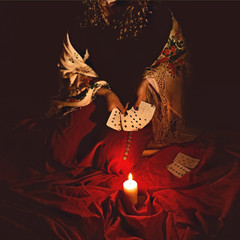 Fortune teller sees in the future by playing her tarot cards in