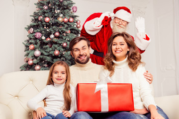 Sticker - Young cheerful family with daughter holding present from Santa