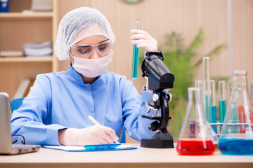 Lab chemist working with microscope and tubes