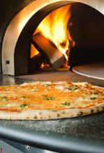 Gourmet Margherita Pizza Fresh From The Pizza Oven, With Wood Flame In The Background