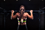 Fototapeta Tulipany - Strong girl in sportswear doing pull up exercise