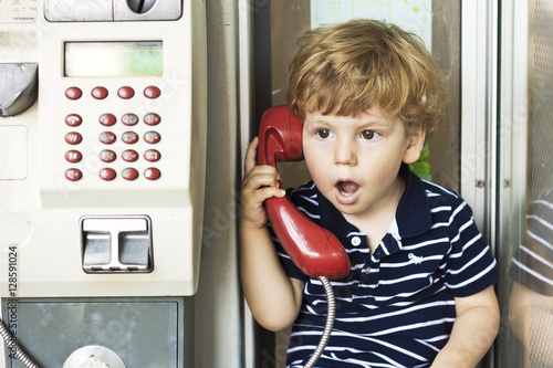 Fotografie, Obraz The emotions of a little boy talking on the phone