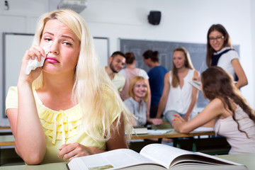 Crying outcast student in college classroom