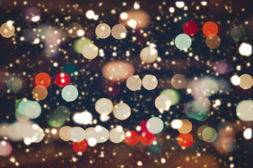 Wall Mural - christmas lights blurred bokeh with snowfall background from night party for your design, vintage or