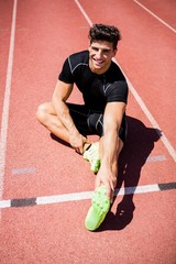 Wall Mural - Tired athlete sitting on the running track