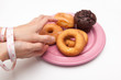 bound with tape-measure woman hand pick up delicious donut and muffin on plate, on white backgrounds, diet concept