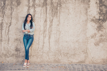 Poster - Young pretty brunette woman on the background of stone wall