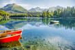 Lake Strbske Pleso with colorful red boats and big mountain on the background in Slovakia. Original wallpaper from summer morning