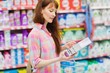 Profile view of woman with shopping basket holding product 