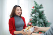 © makistock - Christmas Asian Couple. A handsome man giving her girlfriend/wif