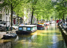 Canal Of Amsterdam, Amstel River With Houseboats And Green Trees, Idyllic Scene.