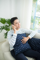 Wall Mural - Young handsome asian man using modern mobile smart phone sitting