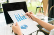 © jannoon028 - Business woman hand with Financial charts and laptop on the tabl