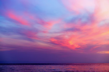 tropical colorful dramatic sunset with cloudy sky and silhouette of the ship on the horizon. evening
