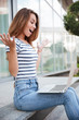 © Drobot Dean - Happy excited young woman using laptop outdoors