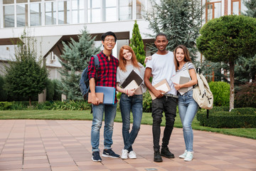 Wall Mural - Happy young people standing in campus together outdoors