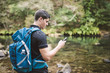 © Westend61 - Hiker looking on smartphone in nature