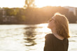 © Westend61 - Young woman relaxing at riverside in the evening twilight